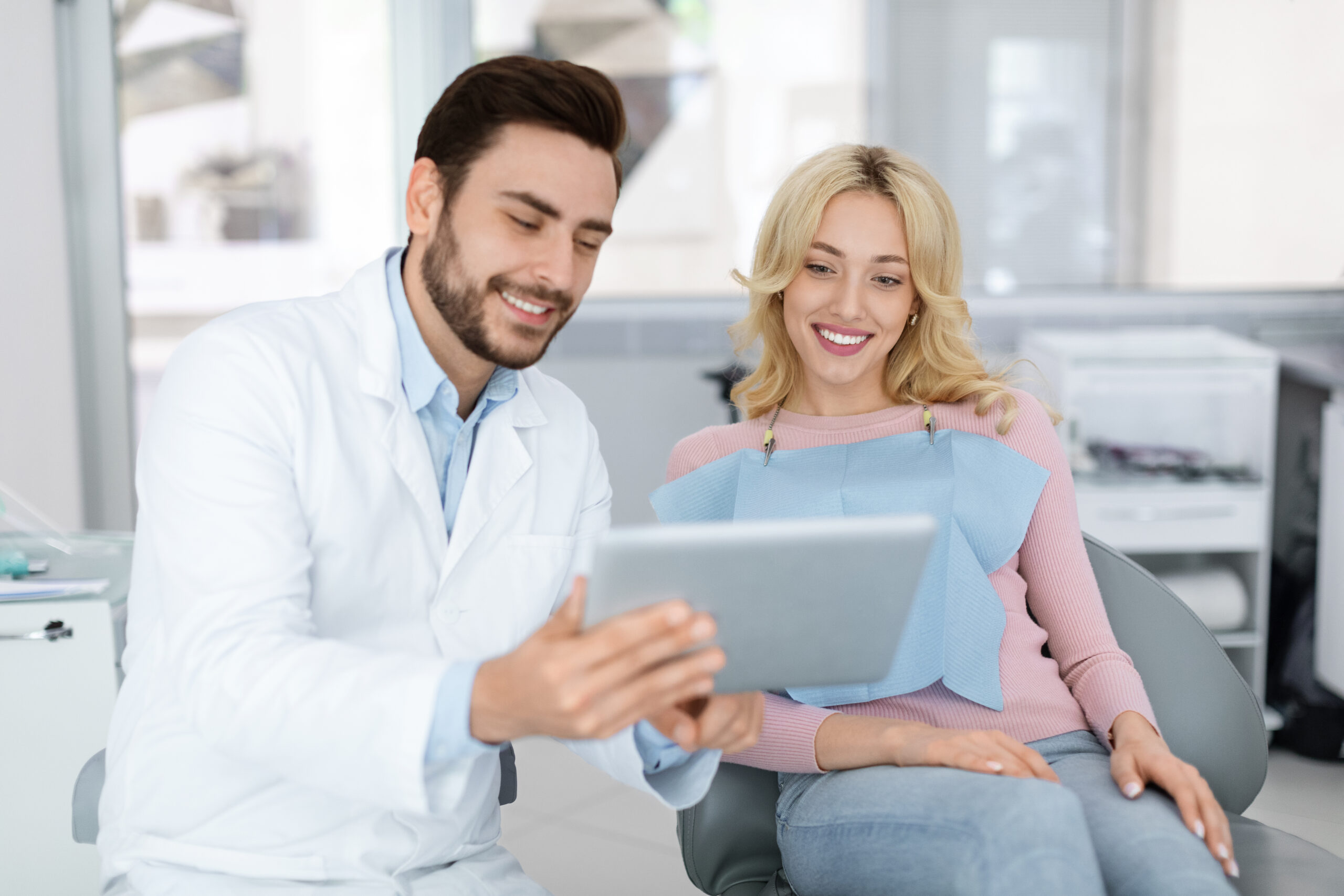 Dentist discussing treatment with patient using tablet